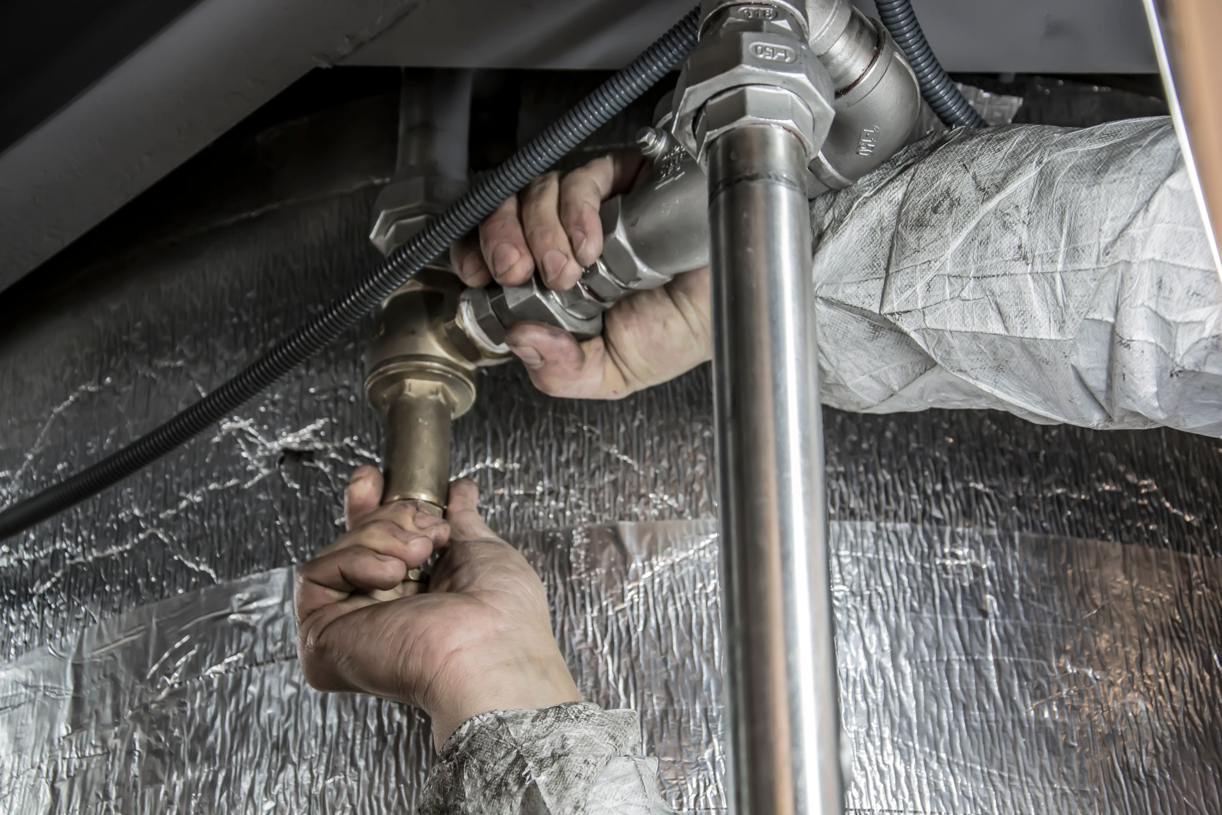 A plumber tightening a fitting on a copper line