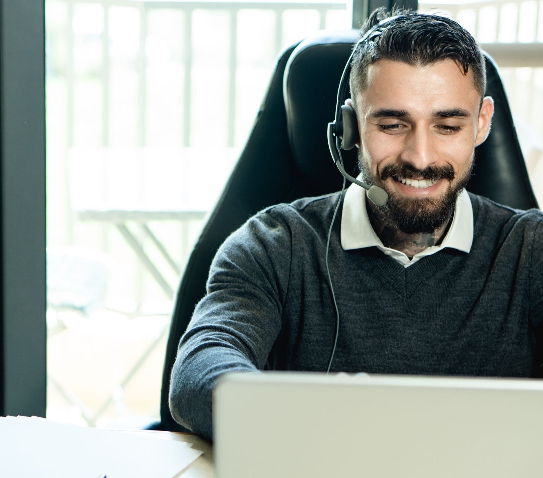 A Corex sales rep on a headset call at a laptop
